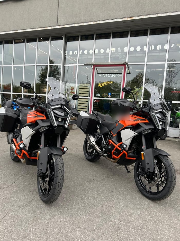Zwei KTM 1290 Super Adventure mit Sturzbügeln, Zusatzscheinwerfern und Koffern vor dem Showroom