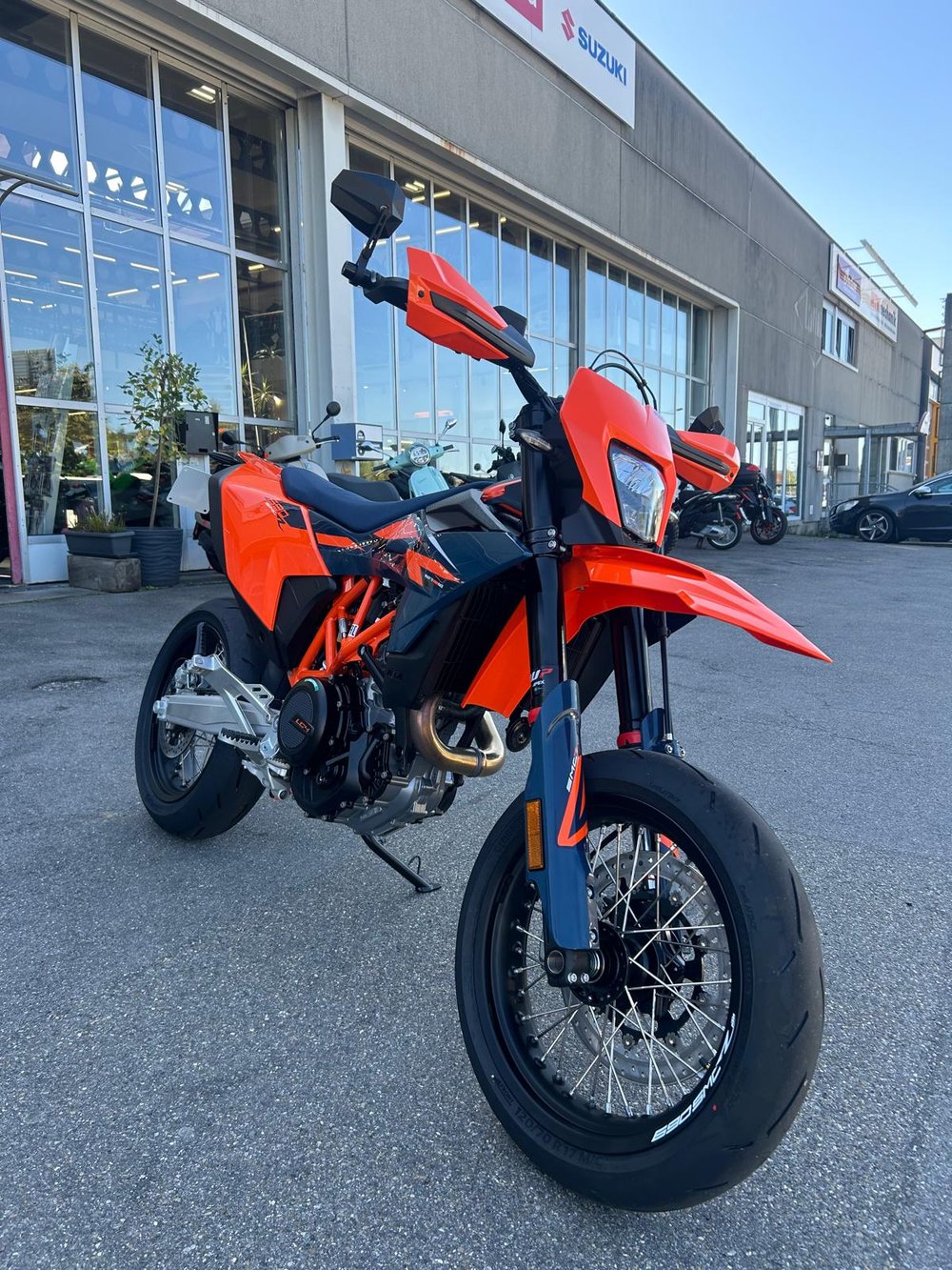 Orange KTM 690 SMC R Supermoto mit Speichenrädern vor dem Moto-Center WEST in St. Gallen