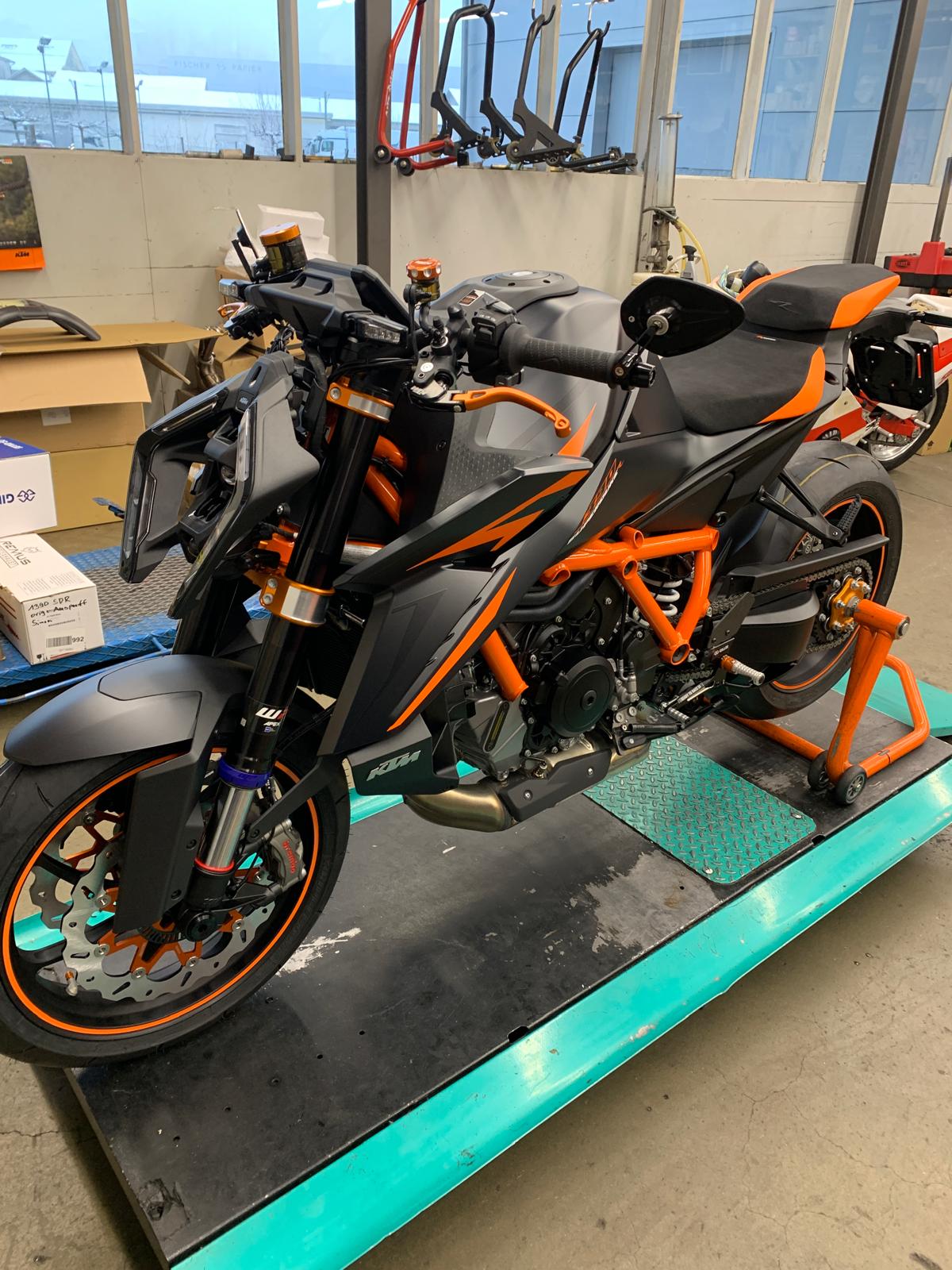KTM 1290 Super Duke R mit orangen CNC-Teilen, WP-Fahrwerk und Bremsscheiben auf dem Montagebock