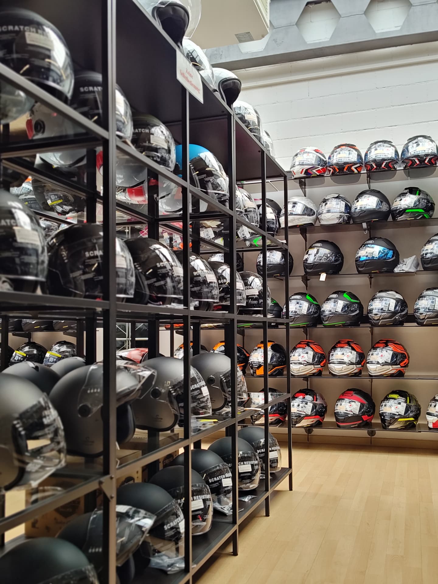 Helm-Wand mit Integral- und Klapphelmen auf Regalen im Moto-Center WEST St. Gallen Helm-Wand mit Integral- und Klapphelmen auf Regalen im Moto-Center WEST St. Gallen